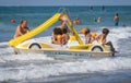 Family on a marine pedal catamaran trying to land across the waves at Marina San Nicola beach in Italy