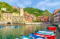 Marina harbor with boats and yachts, promenade, Chiesa di Santa Margherita church, green hill and colorful buildings houses in Ver