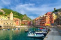 Marina harbor with boats and yachts, promenade, Chiesa di Santa Margherita church, green hill and colorful buildings houses in Ver Royalty Free Stock Photo