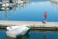 Marina with moored boats in calm blue water and small boy