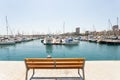 Marina with yachts in Alicante, Spain. Empty bench with view on marina bay, sunny day