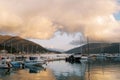 Marina with yachts at the foot of the mountains against the backdrop of orange clouds in the reflections of the sunset Royalty Free Stock Photo