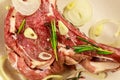 Marinated beef rib eye steak on bone with spices, onion and rosemary on wooden table Royalty Free Stock Photo