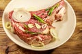 Marinated beef rib eye steak on bone with spices, onion and rosemary on wooden table Royalty Free Stock Photo