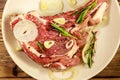 Marinated beef rib eye steak on bone with spices, onion and rosemary on wooden table Royalty Free Stock Photo