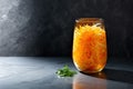 Marinated cabbage and carrots in a glass jar, with parsley, on dark kitchen countertop. Sauerkraut. Generative AI