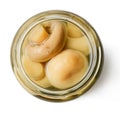 Marinated champignons in a glass jar. White isolated background.