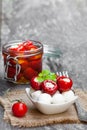 Marinated cherry tomatoes and mozzarella on wooden table