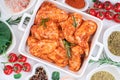 Marinated chicken wings on a baking plate with vegetables, tomatoes and spices. Raw chicken wings Royalty Free Stock Photo