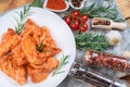 Marinated chicken wings on a plate with vegetables, tomatoes and spices. Raw chicken wings Royalty Free Stock Photo