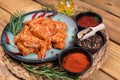 Marinated chicken wings raw.Chicken wings marinated in red sauce on a plate on a wooden background with different spices. Raw Royalty Free Stock Photo