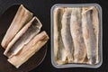 Marinated fillet mackerel or fillet herring fish with oil packed in box on plate over slate stone background. Mediterranean food,