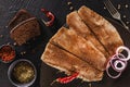 Marinated fillet mackerel or fillet herring fish with spices and slice of bread on plate over dark stone background. Mediterranean