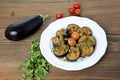 Marinated fried eggplant with cherry tomato and coriander served in dish isolated on wooden table side view of arabic food