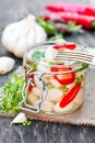 Marinated garlic with mixed chillies and herbs in glass jar Royalty Free Stock Photo