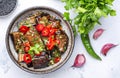 Marinated grilled eggplant with red chili peppers, parsley, sesame seed, soy sauce and garlic, white table background, top view Royalty Free Stock Photo