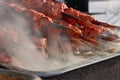 Marinated meat shashlik on preparing on barbecue grill. Roast Beef Kebabs being on BBQ in steam and smoke. Royalty Free Stock Photo