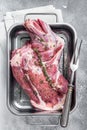 Marinated mutton lamb whole shoulder, raw meat in a steel tray with herbs and spices. White background. Top view Royalty Free Stock Photo