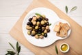 Marinated olives in plate on wooden table. Tasty mediterranean food