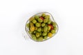 Marinated olives in small transparent bowl. On white background. Pickled green olives Royalty Free Stock Photo