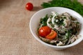 Marinated oyster mushrooms, garnished with cherry tomatoes and green dill. A dish with onions and butter in a white plate with