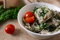 Marinated oyster mushrooms, garnished with cherry tomatoes and green dill. A dish with onions and butter in a white plate with a b