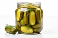 Marinated pickled cucumbers in open glass jar on a white background, close up
