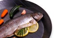 Marinated rainbow trout with lemon, carrot on frying pan