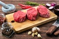 Marinated raw beef steak with spice on wooden table Royalty Free Stock Photo