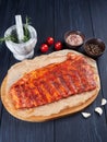 Marinated raw pork spareribs on crumpled paper on a bamboo cutting board Royalty Free Stock Photo