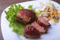 Marinated roaste chicken breasts cooked on BBQ and served with fresh salad on white plate, close-up.