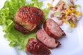 Marinated roaste chicken breasts cooked on BBQ and served with fresh salad on white plate, close-up.