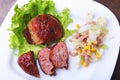 Marinated roaste chicken breasts cooked on BBQ and served with fresh salad on white plate, close up.