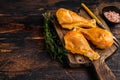 Marinated and Smoked chicken legs drumsticks on a wooden cutting board. Dark wooden background. Top view. Copy space Royalty Free Stock Photo