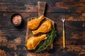 Marinated and Smoked chicken legs drumsticks on a wooden cutting board. Dark wooden background. Top view Royalty Free Stock Photo