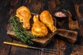 Marinated and Smoked chicken legs drumsticks on a wooden cutting board. Dark wooden background. Top view Royalty Free Stock Photo