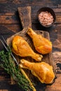 Marinated and Smoked chicken legs drumsticks on a wooden cutting board. Dark wooden background. Top view Royalty Free Stock Photo