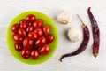 Marinated tomato cherry in bowl, garlic, dried chili peppers on Royalty Free Stock Photo