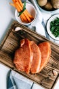 Marinated turkey steak with spices on a wooden board with carrot sticks and herbs on the table Royalty Free Stock Photo