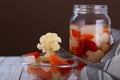 Marinated various vegetables in a glass jar on white wooden background Royalty Free Stock Photo