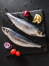 Marinated whole mackerel or herring fish with spices, lemon and onion on slate stone background. Mediterranean food, appetizer,