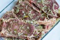 Marinating meat with spices, close up. Fresh-marinated raw steak with herbs and spices. Royalty Free Stock Photo