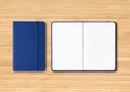 Marine blue closed and open lined notebooks on wooden background Royalty Free Stock Photo