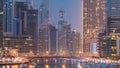 Evening Dubai marina city centre with floating vessels day to night timelapse Royalty Free Stock Photo