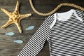 Marine concept of baby clothes on wooden background