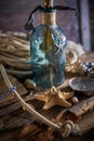 A marine concept with a bottle, starfish, seashells, rope, compass and paper scroll, pirate still life