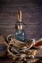 A marine concept with a bottle, starfish, seashells, rope, compass and paper scroll, pirate still life