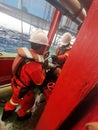 Marine crew with full PPE connect cargo hose for jack up rig