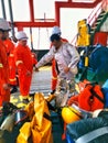 Marine crew preparing safety fire outfit for fire drill