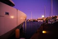 View beyond ship bow of luxury yacht with reflection of street light on mediterranean Harbour in late evening